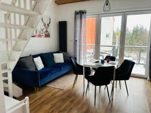 a living room with a blue couch and a table at Natura Taszów in Lewin Kłodzki