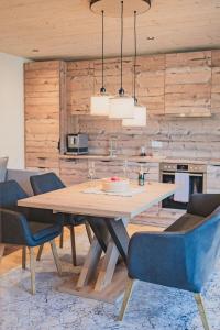 une salle à manger avec une table en bois et des chaises bleues dans l'établissement Apartment Aurelian, à Vandans