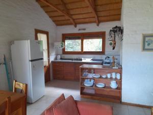 eine Küche mit einem weißen Kühlschrank und einem Tisch in der Unterkunft Posada Yaguane in La Paloma