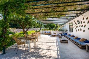 patio con tavoli e sedie sotto un pergolato di Sopramare Resort a Piano di Sorrento