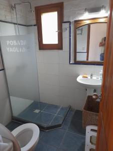 ein Badezimmer mit Dusche, Toilette und Waschbecken in der Unterkunft Posada Yaguane in La Paloma