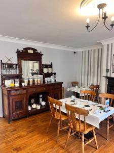 uma sala de jantar com uma mesa e cadeiras de madeira em Fiddlestone Bar and B&B em Belleek