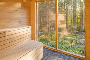 a sauna with a large window in a forest at Tretoppen - Ny moderne hytte, Unike Finnskogen in Torsby