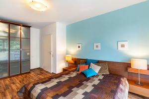 バーデン・バーデンにあるFerienwohnung Am Paradiesの青い壁のベッドルーム1室(大型ベッド1台付)