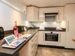 a kitchen with white cabinets and a counter at Inglewood Court in Carnforth