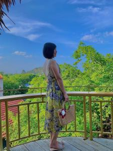 a woman standing on a balcony looking out at the mountains at Trang An ViewPoint Homestay in Ninh Binh +118 photos