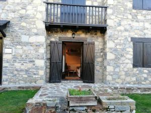 wejście do kamiennego budynku z balkonem w obiekcie Acogedor estudio con terraza Besiberri 4 w mieście Pla de l'Ermita