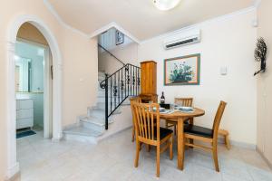 a dining room with a table and chairs and a staircase at Garden Sweets Chalet in Orihuela