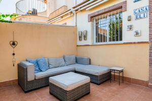 Un patio con un sofá y una otomana en un edificio. en Garden Sweets Chalet, en Orihuela