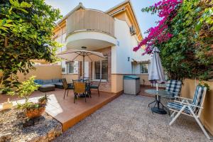 a patio with a table and chairs and an umbrella at Garden Sweets Chalet in Orihuela