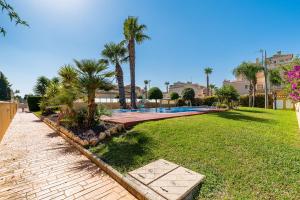 a yard with a swimming pool and palm trees at Garden Sweets Chalet in Orihuela