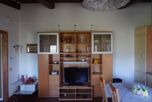 a living room with a tv and a table with chairs at Casa Tre Pini in Serravalle Pistoiese