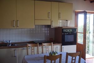 a kitchen with a table and chairs and a sink at Casa Tre Pini in Serravalle Pistoiese