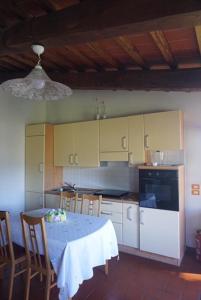 a kitchen with a table and chairs and a kitchen with yellow cabinets at Casa Tre Pini in Serravalle Pistoiese