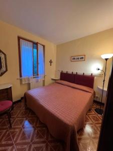 ガルニャーノにあるCasa Elisaのベッドルーム1室(赤いベッドカバー付)