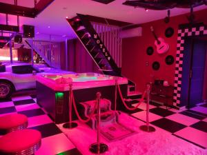 a music room with pink lighting and a staircase at LE QUART D'HEURE AMERICAIN in Bailleul