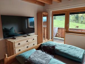 een slaapkamer met een bed en een dressoir met een televisie bij Ferienwohnung am Arzberg in Schwaz