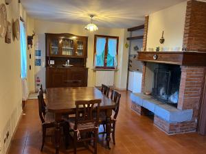 a dining room with a table and a fireplace at Casa Elisa in Gargnano