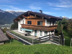 a house on a hill with mountains in the background at Ferienwohnung am Arzberg in Schwaz
