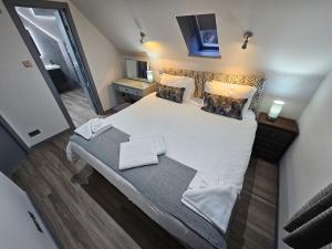 um quarto com uma cama grande com lençóis brancos e almofadas em Melfort Pier & Harbour Resort em Kilmelfort