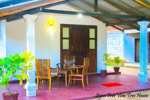 a patio with a table and chairs in a house at Sigiriya Free View Tree House & Villa in Sigiriya
