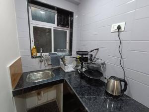 a kitchen counter with a sink and a stove at Private Studio Apartment in South Mumbai's Heart in Mumbai