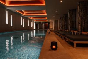 a swimming pool in a hotel with couches and a candle at The Nici in Bournemouth