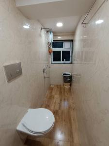 a bathroom with a white toilet and a window at Private Studio Apartment in South Mumbai's Heart in Mumbai
