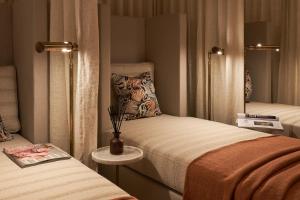 a small bedroom with two beds and a vase on a table at The Nici in Bournemouth