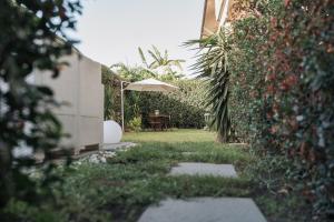 un giardino con tavolo e ombrellone di Grey's Apartment a Catania