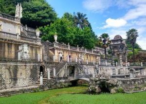 um antigo edifício de pedra com uma ponte num quintal em Casa Montecelo em Paderne