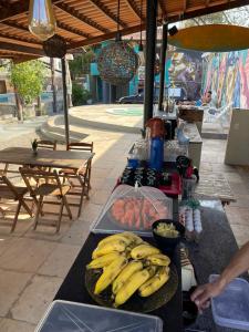 Salve Maloca Hostel في فورتاليزا: طاولة مع الموز والأطعمة الأخرى على منضدة