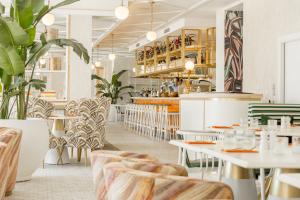 un ristorante con tavoli e sedie bianchi di The Nici a Bournemouth