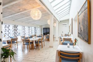 een restaurant met tafels en stoelen en een kroonluchter bij Hotel Herning in Herning