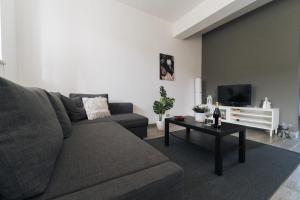 un soggiorno con divano e tavolo di Grey's Apartment a Catania