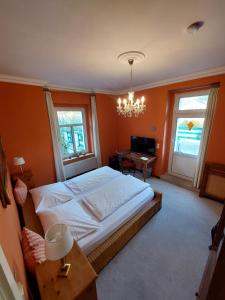 a bedroom with a large bed and a chandelier at Plantagengut Hosterwitz in Dresden