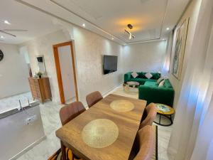 sala de estar con mesa y sofá verde en A2 Appartement entièrement neuf au cœur de Témara en Temara