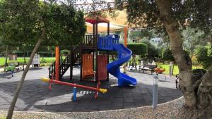 un parque infantil con un tobogán azul en Thalassa Beach Resort, en Trikomo