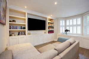 a living room with a couch and a flat screen tv at Veeve - Pine Glow Perfection in London