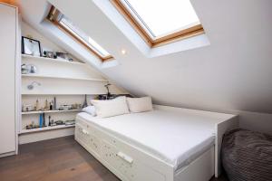 a small attic bedroom with a bed and a skylight at Veeve - Pine Glow Perfection in London