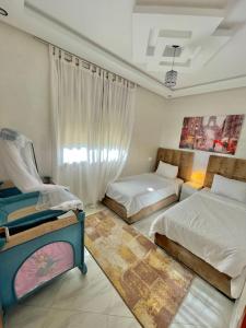 特馬拉的住宿－Appartement entièrement neuf au cœur de Témara，一间卧室设有两张床和窗户。