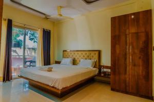 a bedroom with a bed and a large window at oakwood mahabaleshwar in Mahabaleshwar