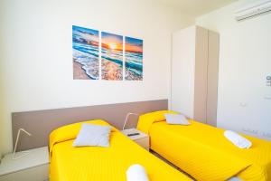 twee bedden in een kamer met gele bedden bij Alloggio Gallinara a due passi dal mare in Liguria in Albenga