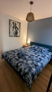 - une chambre avec un lit et une couette bleue dans l'établissement Studio Parc Carrières Bacquin à 5 minutes de la gare, à Dijon