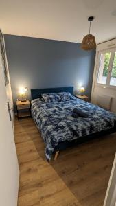 een slaapkamer met een bed met een blauwe muur bij Studio Parc Carrières Bacquin à 5 minutes de la gare in Dijon