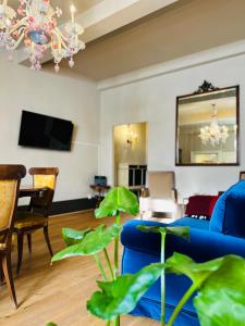 ein Wohnzimmer mit einem blauen Sofa und einem TV in der Unterkunft Domus An- Two Bedrooms Apartment -Antique and Historical Home in Siena