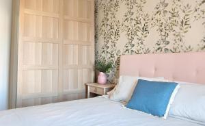 1 dormitorio con cama blanca y almohada azul en Alojamientos Rurales Las Candelas en Santa Marta de Magasca