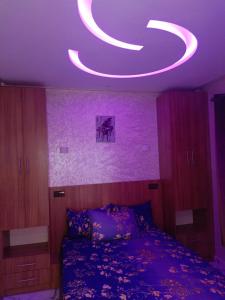 um quarto com uma cama com um tecto roxo em Aourir's new appartement em Agadir