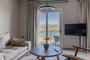 a living room with a couch and a table and a large window at Chelmis Sea Front Apartments - Oceanis in Argostoli