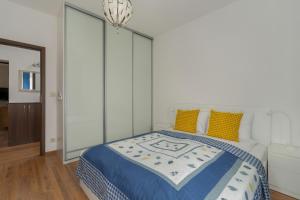 1 dormitorio con 1 cama grande con almohadas amarillas en Traditionally Furnished Apartment with Balcony in Poznan by Renters en Poznan